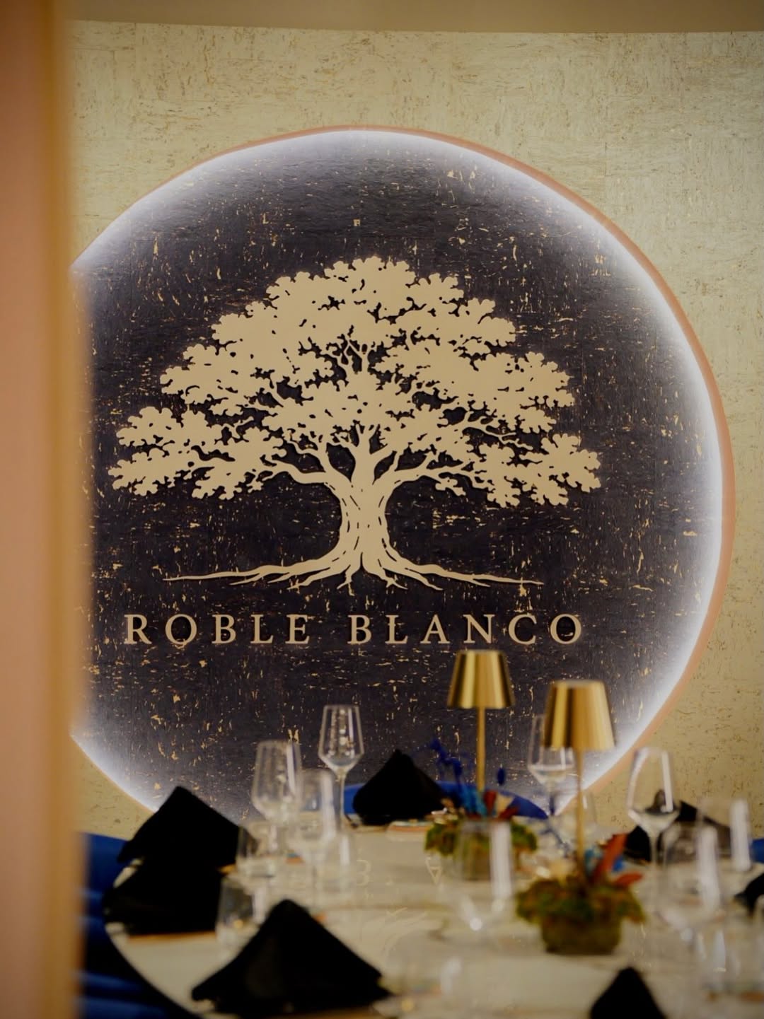 Mesa preparada frente al árbol iluminado de Roble Blanco