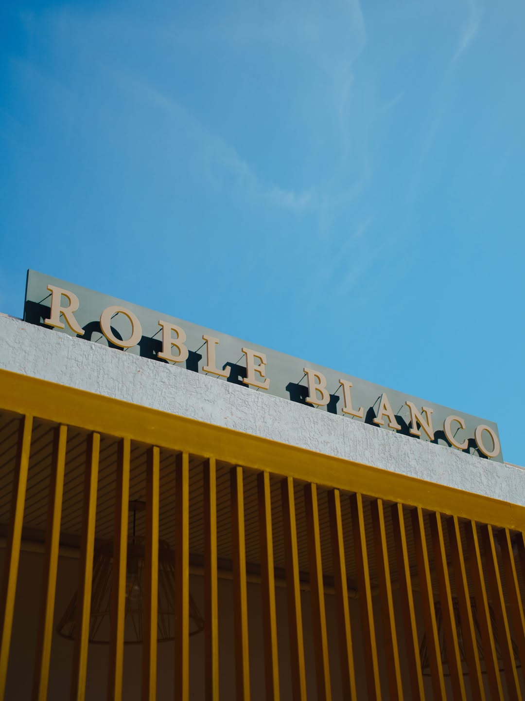 Letrero de Roble Blanco sobre la fachada del restaurante bajo el cielo azul